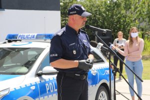 Zdjęcie przedstawia przemawiającego policjanta
