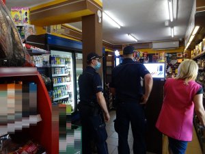 Policjanci sprawdzają noszenie maseczek przez klientów sklepu