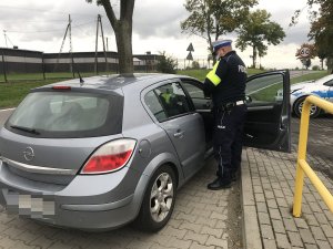 policjant kontroluje auto osobowe