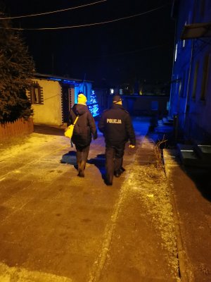 Policjant wspólnie z pracownikiem socjalnym kontrolują miejsce przebywania osób bezdomnych